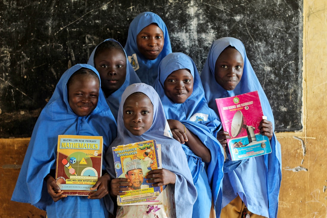 Groupe d'écolières souriantes tenant des manuels scolaires